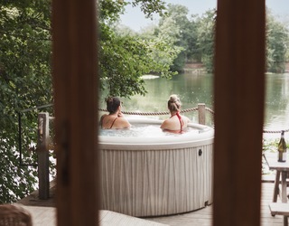 Two women in a hot tub overlooking a lake