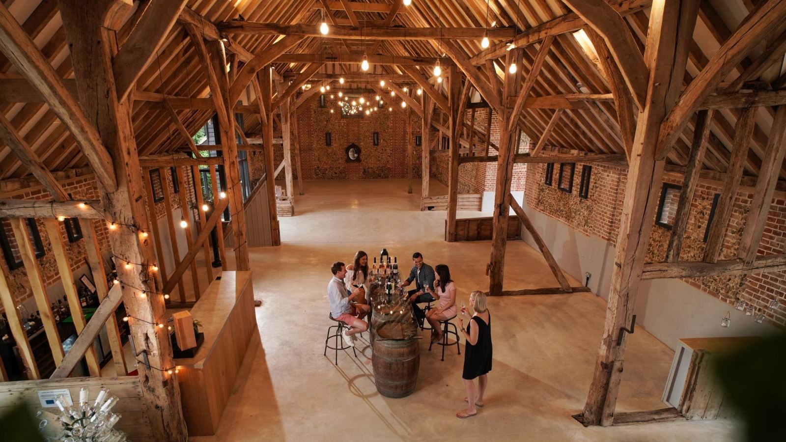 Group of people wine tasting in a large barn at Tuffon Hall Vineyard