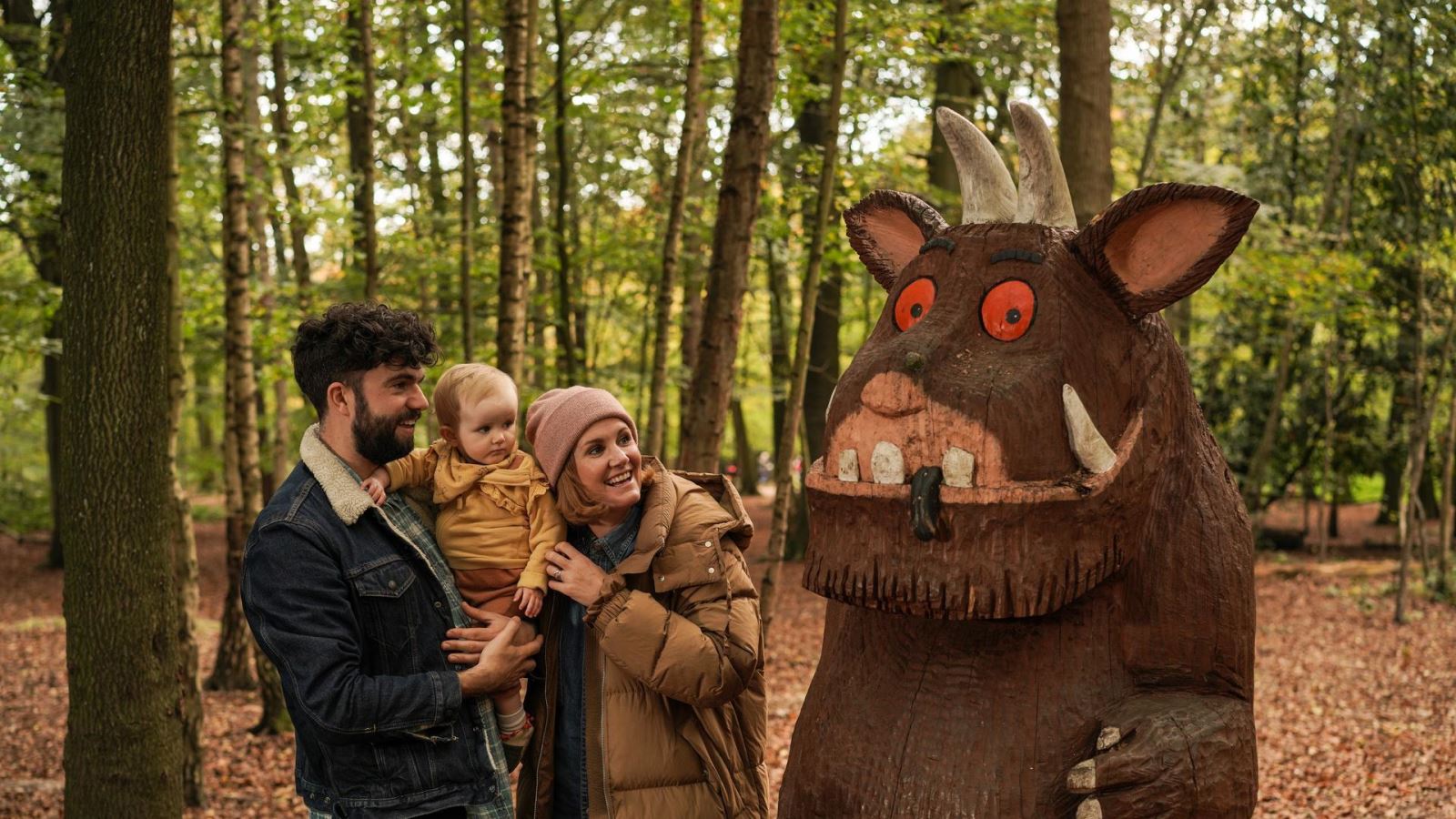Mum, Dad and Child Standing next to Gruffalo statue 
