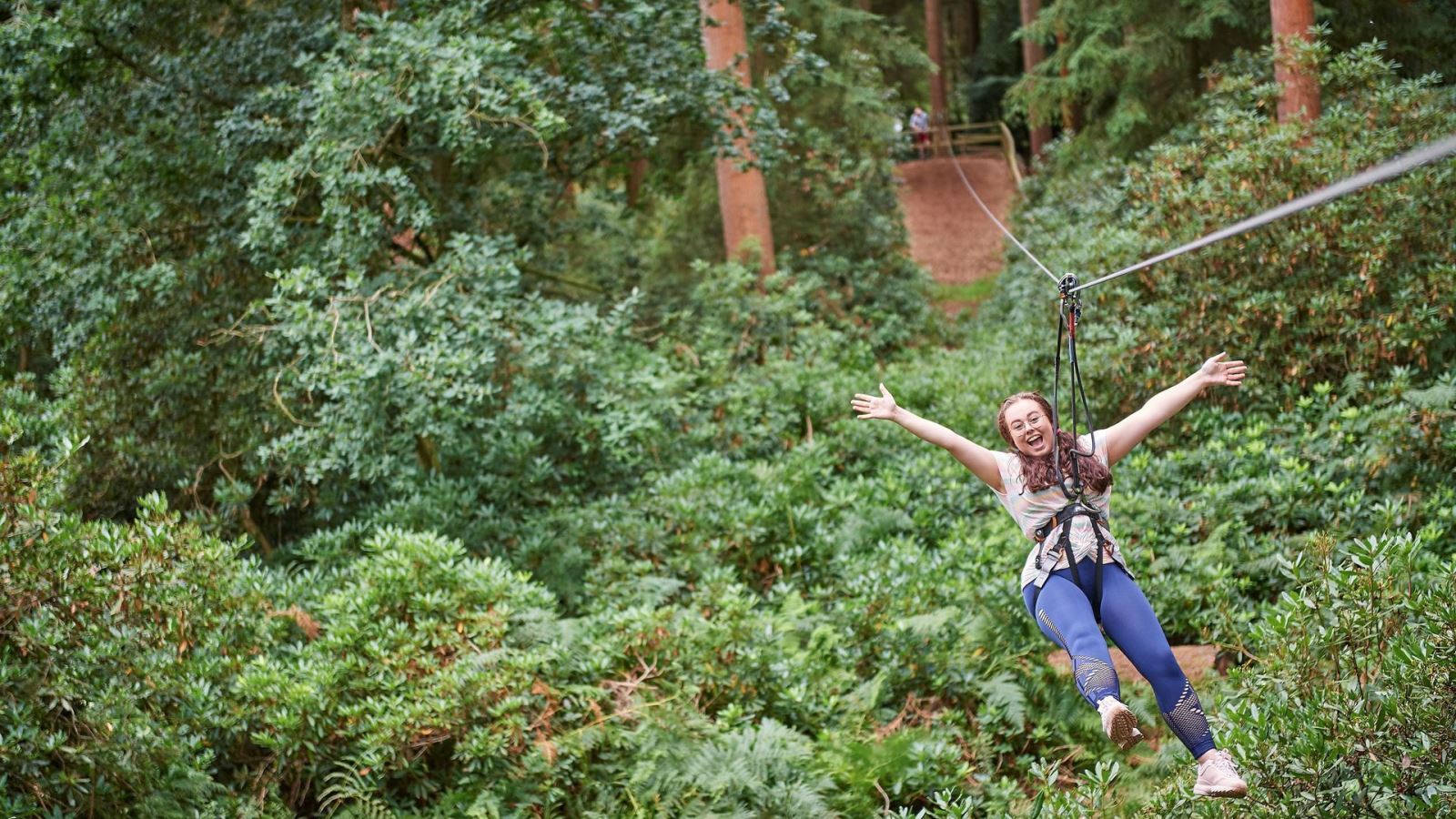 Girl on zipline amongst the trees at Go Ape Chelmsford, Essex